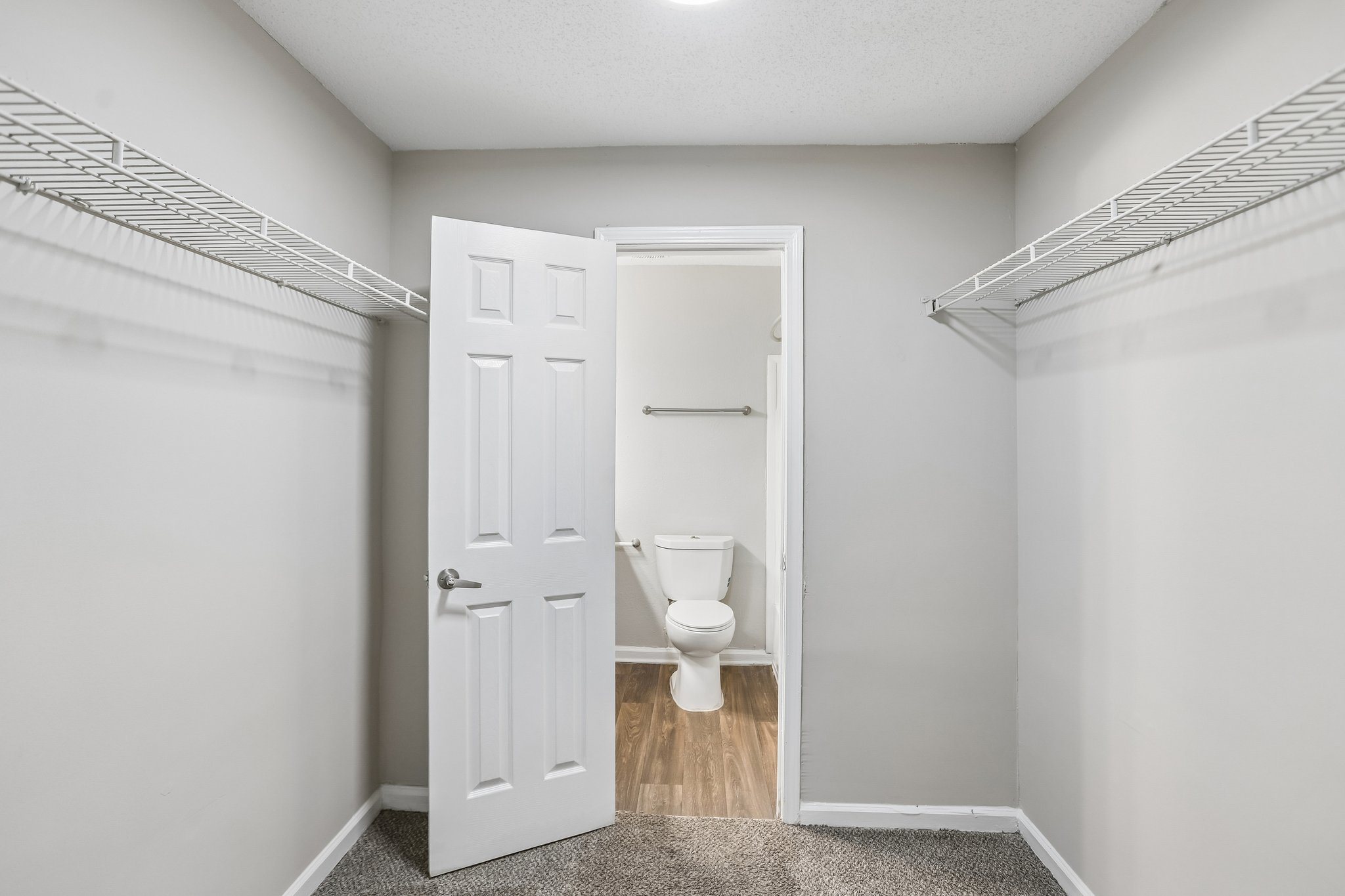 A white door is open to a bathroom with a toilet.